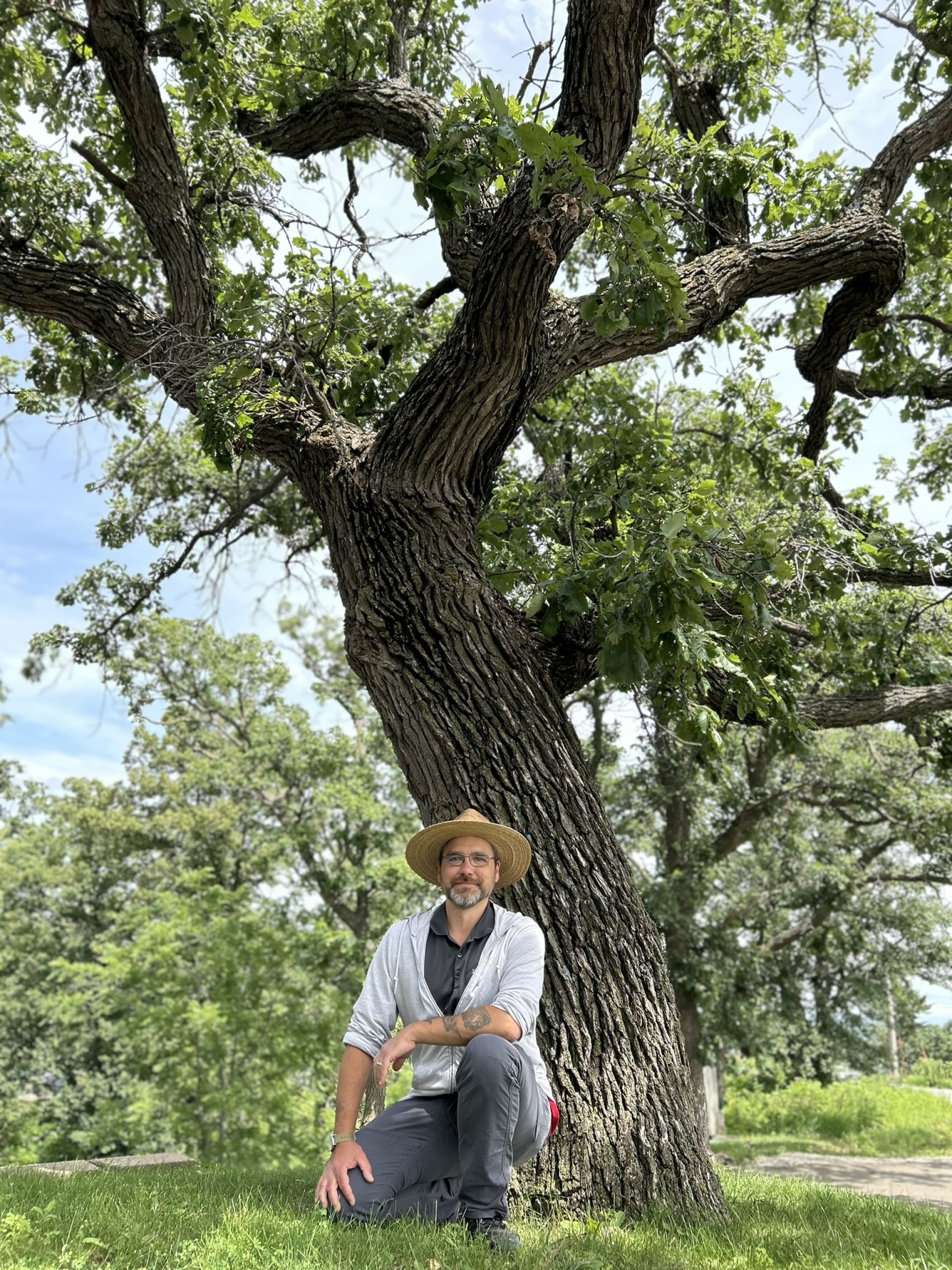 Dustin Clayton in front of a Bur Oak tree.